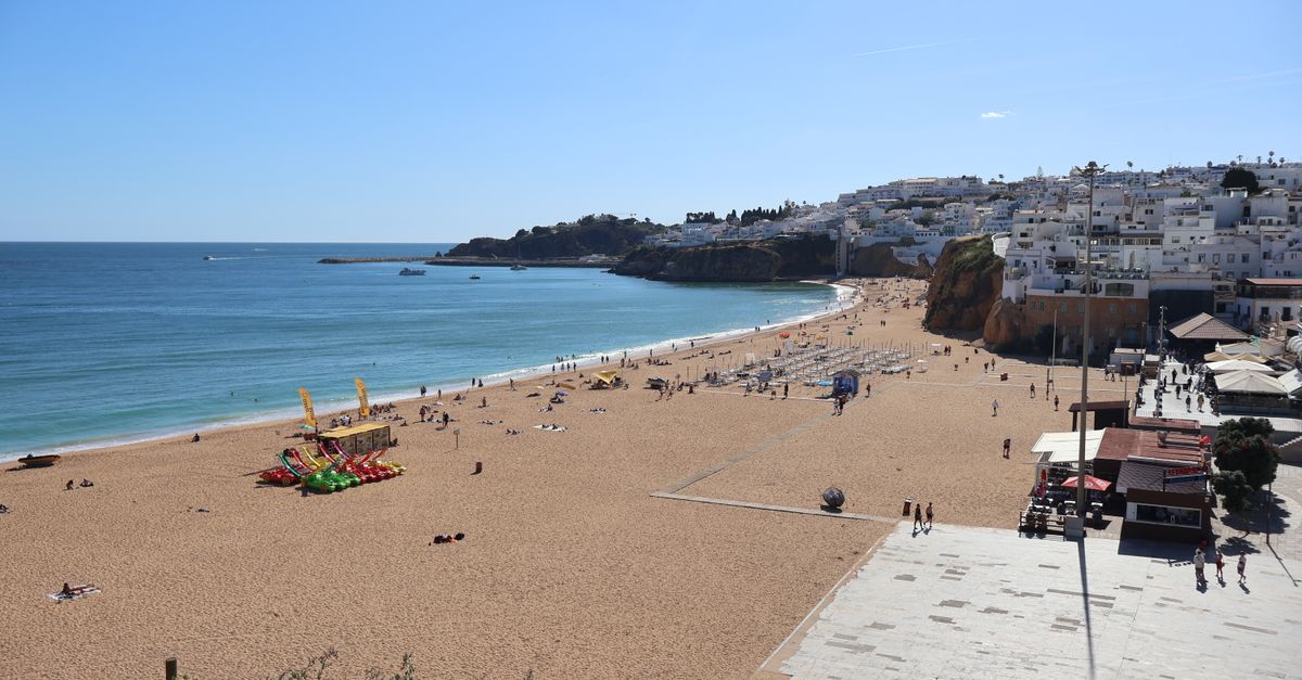 Albufeira town beach with promenade, pedal boats and the white houses of the old town on the cliff